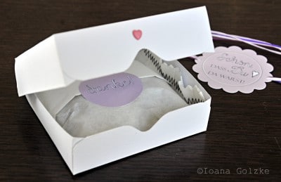 Weiße Geschenkbox mit transparentem Fenster, dekoriert mit einem kleinen Herz und Dankeschön-Aufkleber, ideal für handgemachte Kekse und Süßigkeiten.