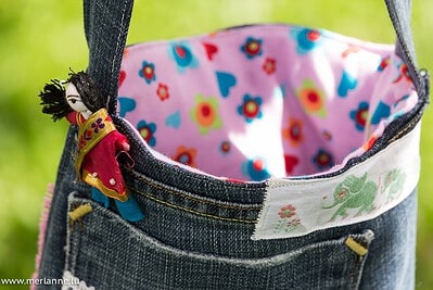 Handgemachte Jeans-Tasche mit buntem Innenfutter, ideal für nachhaltige Mode und Recycling für kleine Mädels, passend zum Thema Handmade Kultur.