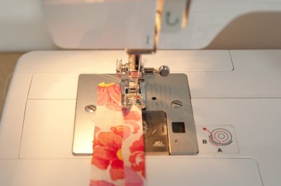 Naht an einem Stoff mit Blumenmuster, genäht mit einer Nähmaschine, für Handarbeit und Textilgestaltung.