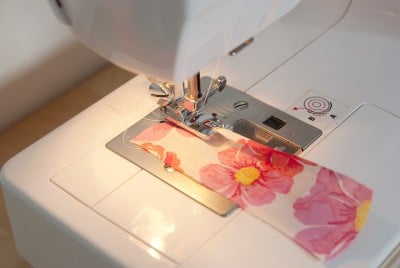Naht an einem Stoff mit Blumenmuster, genäht mit einer Nähmaschine, für handgefertigte Textilprojekte und kreative Näharbeiten.