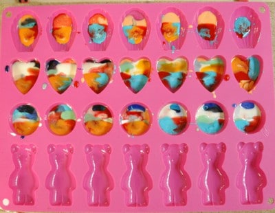 Bunte Schmucksteine aus Harz in einer pinken Silikonform, ideal für handgemachten Schmuck, kreative Bastelideen, DIY Schmuckherstellung, handgemachte Accessoires.