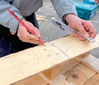 Handwerker baut ein Küchenregal aus alten Paletten, zeigt den Einsatz von Holz und handwerkliches Geschick für nachhaltige Küchenmöbel.