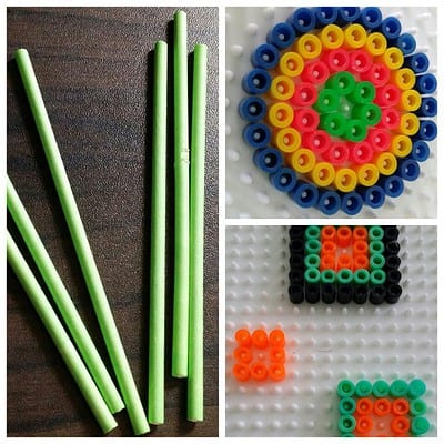 Bügelperlen Kreisel aus bunten Perlen auf einer Perlenplatte, mit grünen Stäbchen zum Zusammenbauen, kreative Bastelarbeit für Kinder.