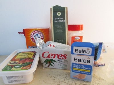 Verschiedene natürliche Zutaten für Fußpeeling, darunter Kokosöl, Tonerde, Backpulver, Zitronenextrakt und Badezusätze, ideal für die Pflege der Füße.