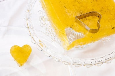 Selbstgemachtes Löwenzahn-Blüten-Gelee in einer Glasschale mit Herzförmigem Ausstecher, ideal für kreative Frühlingsdesserts.