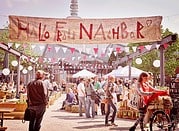 Bunte Marktstände und Menschen beim HANDMADE Kultur Event mit handgemachten Produkten und Gemeinschaftsatmosphäre.