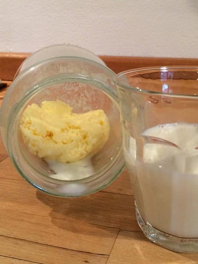 Frisch zubereitete Butter in Gläsern mit Milch, ideal für hausgemachte Butterrezepte.