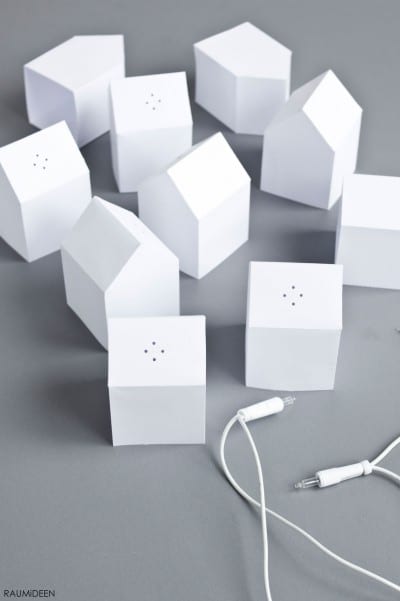 Miniatur-Häuser aus weißem Material, ideal für festliche Dekorationen und kreative Beleuchtungsideen, mit Kabel und Stecker für einfache Nutzung.