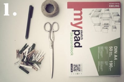 Zeichenblock, Schere, Stift, Garn und Clips für kreatives Basteln und Handarbeit, passend für DIY-Projekte und künstlerische Gestaltung.