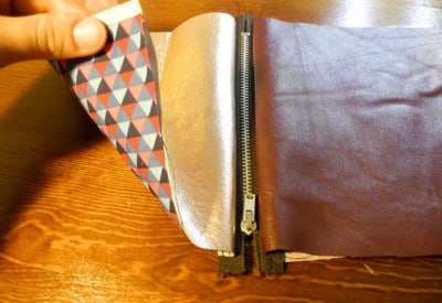 Handgefertigtes Lederwende-Täschchen mit geometrischem Muster auf der Außenseite, geöffnet, zeigt den Reißverschluss und das Innenfutter, ideal für Krimskrams.