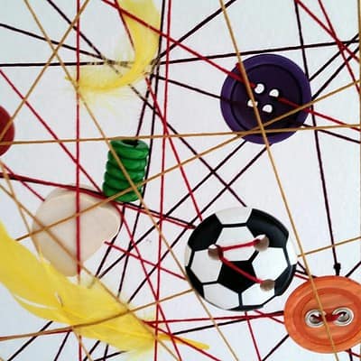 Kreativer Traumfänger mit bunten Knöpfen, Federn und Garn, handgemacht, ideal für kreative Dekorationen und als Geschenk, passend zum Thema Traumfänger mal anders.