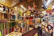 Vielfältige Stoffe, Nähzubehör und handgemachte Textilien in einem kreativen Handarbeitsladen, ideal für DIY-Projekte und kreative Bastelarbeiten.