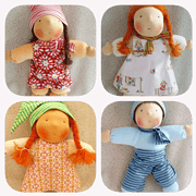 Vier handgefertigte Stoffpuppen mit bunten Kleidern und Haaren, ideal für Kinder und als Dekoration, hergestellt aus weichen Stoffen und liebevoll gestaltet.