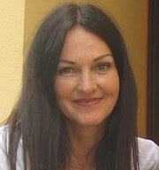 Porträt einer Frau mit dunklem Haar, freundlichem Lächeln, in einem kreativen Umfeld, ideal für Handmade Kultur, Kunsthandwerk, kreative Projekte.