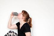 Junge Frau trinkt Wasser aus einer Flasche, symbolisiert bewussten Umgang mit Ressourcen und nachhaltigen Lebensstil bei HANDMADE Kultur.