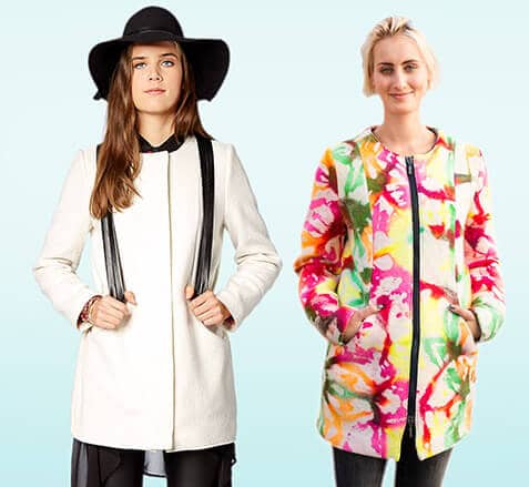 Zwei junge Frauen tragen modische Jacken, eine in klassischem Weiß mit schwarzen Akzenten, die andere in buntem, künstlerischem Design, passend zum Thema Miss Jacky Coat Schnittmuster.