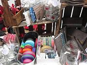 Vielfältiges Bastelmaterial mit bunten Bändern, Knöpfen und Dekorationsartikeln für kreative Handarbeiten bei Handmade Kultur.
