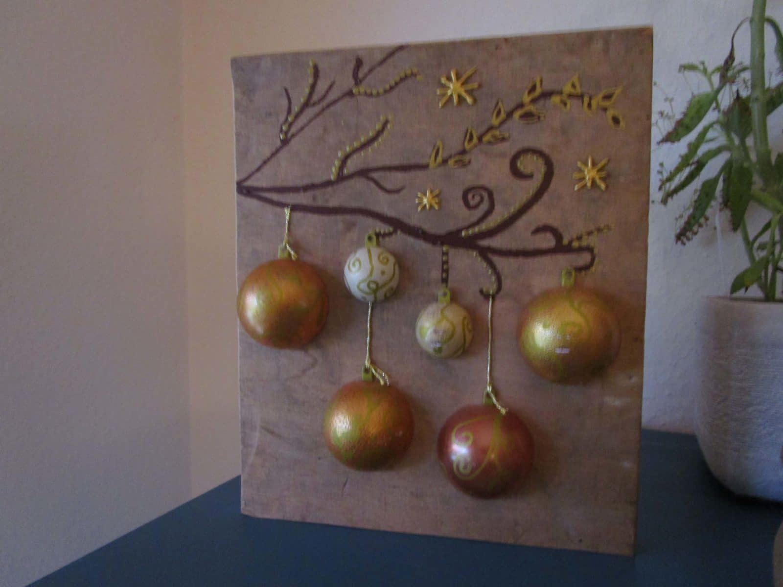 Beleuchtetes Bild mit Weihnachtskugeln auf Holz
