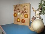 Beleuchtetes Bild mit Weihnachtskugeln auf Holz