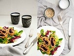 knusprig gebratene Rotkraut Roulade aus Kartoffel-Rote Beete Teig auf einem Bett aus Salat