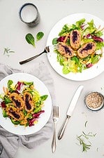 knusprig gebratene Rotkraut Roulade aus Kartoffel-Rote Beete Teig auf einem Bett aus Salat