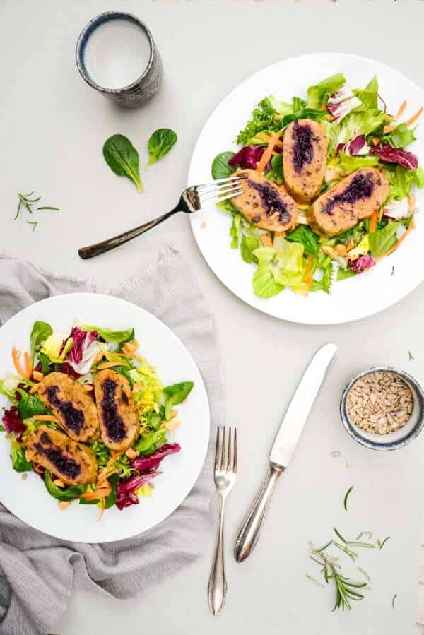 knusprig gebratene Rotkraut Roulade aus Kartoffel-Rote Beete Teig auf einem Bett aus Salat