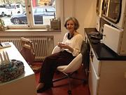 Frau beim kreativen Handarbeiten in einem gemütlichen Raum, umgeben von handgemachten Kunstwerken und kreativen Materialien, die die Leidenschaft für Handmade-Kultur zeigen.