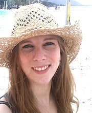 Lächelnde Frau mit Strohhut am Strand, Sonne, Sand, Wasser, Urlaub, Sommer, Natur, Freizeit, Entspannung, Naturfotografie.