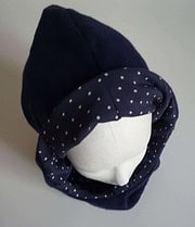 Handgefertigte Mütze mit passendem Schal, ideal für kalte Tage, aus weichem Stoff, in dunkler Farbe mit weißen Punkten, für stilvolle Wintermode.