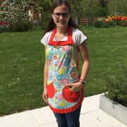 Frau trägt bunte Blumenapplikation aus Stoff mit rotem Rand, ideal für Handmade- und DIY-Projekte, zeigt kreative Handarbeit und individuelle Gestaltung.