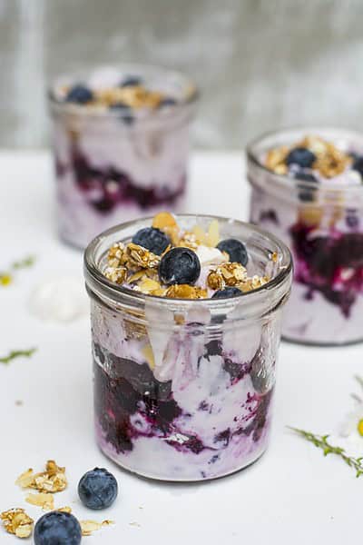 eisgekühltes Blaubeer Dessert im Glas mit knusprigem Erdnussriegel-Krokant Topping