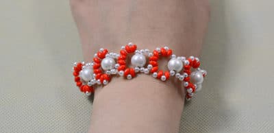Erstellen einer Orange 2-Loch-Samenperlen und weiße Perlen gewebten Armband