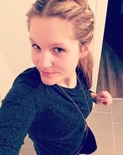 Porträt einer jungen Frau mit blonden Haaren, blauen Augen und dunklem Pullover, die für Handmade Kultur fotografiert wurde.