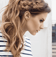 Frau mit lockigem, braunem Haar und gestreiftem Oberteil, stilvoll und modern, für Mode- und Lifestyle-Blogs geeignet.