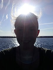 Silhouette einer Person am Wasser bei Sonnenuntergang, kreative Lichtspiele, entspannte Atmosphäre, Natur, Freizeit, Outdoor-Aktivitäten, ruhige Umgebung, schöne Landschaft, Sonnenlicht, Wasserreflexe.