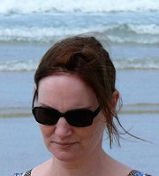 Frau mit Sonnenbrille am Strand, entspannt und genießt die Meeresbrise, perfekte Darstellung für Handmade Kultur und sommerliche Freizeitmomente.