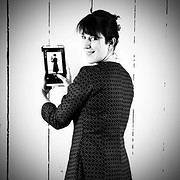 Frau mit dunklem Haar und gepunktetem Kleid fotografiert sich selbst mit Smartphone, kreative und moderne Handwerkskunst, DIY, Selbstporträt, Lifestyle, Kunsthandwerk.