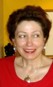 Frau mit kurzen braunen Haaren, rotem Oberteil, silberner Halskette und Ohrringen, lächelnd, bei HANDMADE Kultur Veranstaltung.