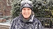 Lächelnde Frau trägt Winterkleidung und Mütze, umgeben von verschneiter Natur, bei Handmade Kultur Veranstaltung, Fokus auf Handarbeit und Wintermode.
