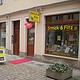 Handarbeitsgeschäft 'Strick & Fitz' mit bunten Wolle und Strickzubehör im Schaufenster, Außenansicht in einer Fußgängerzone, einladend für Handarbeitsliebhaber.