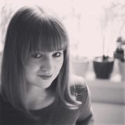 Schwarz-weiß Porträt einer jungen Frau mit geraden Haaren und einem freundlichen Blick, ideal für Themen zu Handarbeit, Kreativität und Kultur.