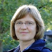 Porträt einer Frau mit Brille und kurzen Haaren, umgeben von grüner Natur, symbolisiert Handarbeit und Kreativität im Rahmen von HANDMADE Kultur.