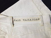 Vintage Kleidungsstück mit Aufnäher 'Paid Vacation' auf der Innenseite des Hosenbunds, detailreiche Textur und Stoffqualität sichtbar.