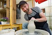 Mann formt eine Keramikvase auf der Töpferscheibe, zeigt handwerkliches Geschick und kreative Handarbeit bei HANDMADE Kultur.