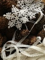 weihnachtliche Türdeko aus Tannenzapfen und Spitze
