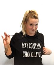 Junge Frau trägt Hoodie mit Aufdruck 'May Contain Chocolate' und hält eine Zigarettenspitze, kreative Mode und DIY-Handwerkskunst, für Handmade Kultur.