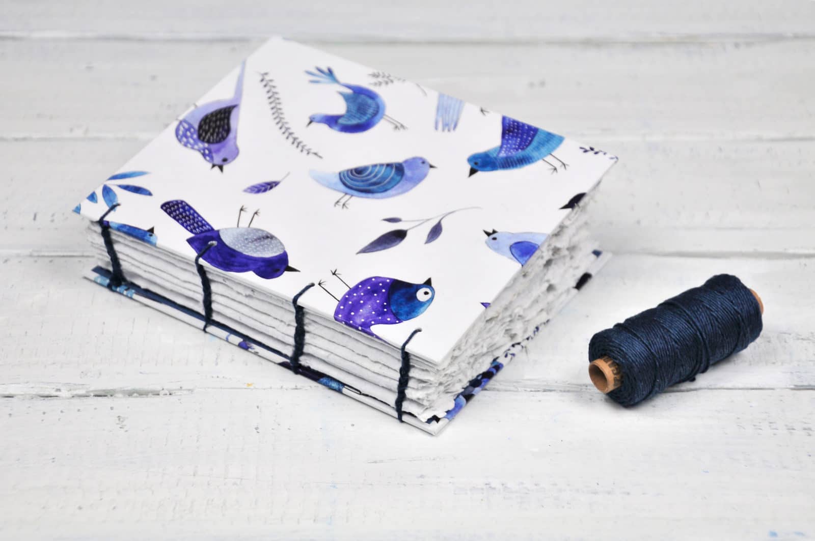 Papierschöpfrahmen und selbstgemachtes Papier (zu einem Notizbuch zusammengebunden)