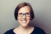 Lächelnde Frau mit kurzen braunen Haaren und schwarzen Brille, professionelles Porträt für Handmade Kultur, kreative Handwerkskunst, authentisch und freundlich.