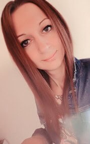 Porträt einer jungen Frau mit roten Haaren, die handgemachte Kunstwerke präsentiert, ideal für Handmade- und Kreativkunst-Themen.