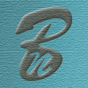 Handmade Kultur Logo auf einer blauen Holzoberfläche, symbolisiert kreative Handwerkskunst und nachhaltige Produktion.